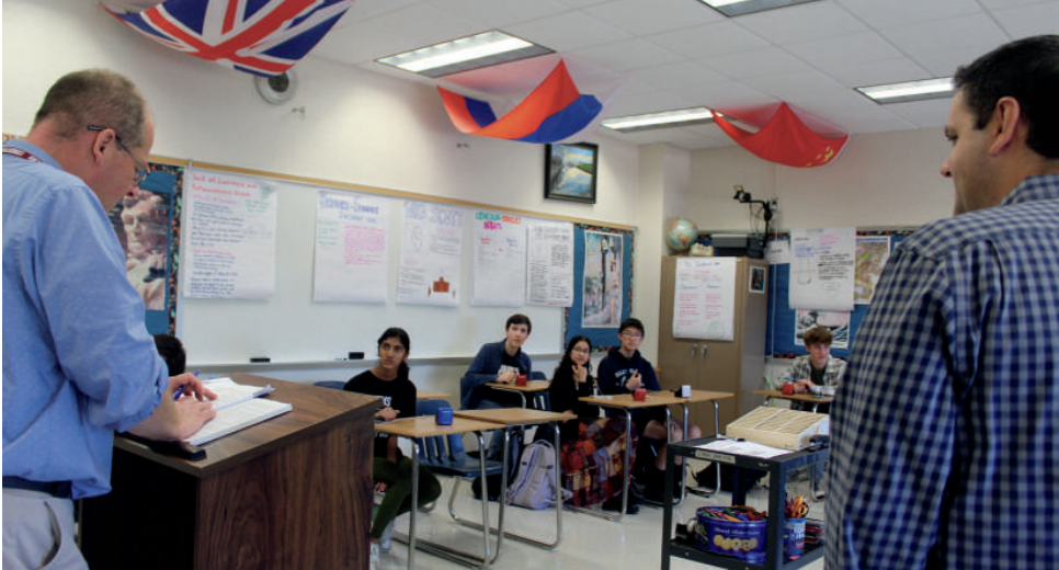 Shared time: Academic Competition Club advisers Michael Cruz and Michael Palmatier speak with members during the new “Lunch and Learn” period. The school board approved the schedule, including the hour-long lunch block, on Jan. 2.